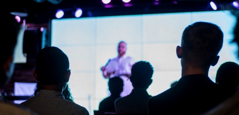 Audience listening to a corporate presentation during an AI transformation discussion